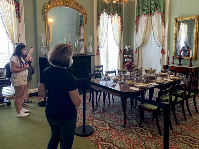 people looking at a furnished room in a museum, one of the things to do in Savannah