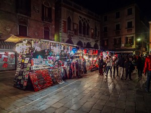 people walking through a night market in Venice