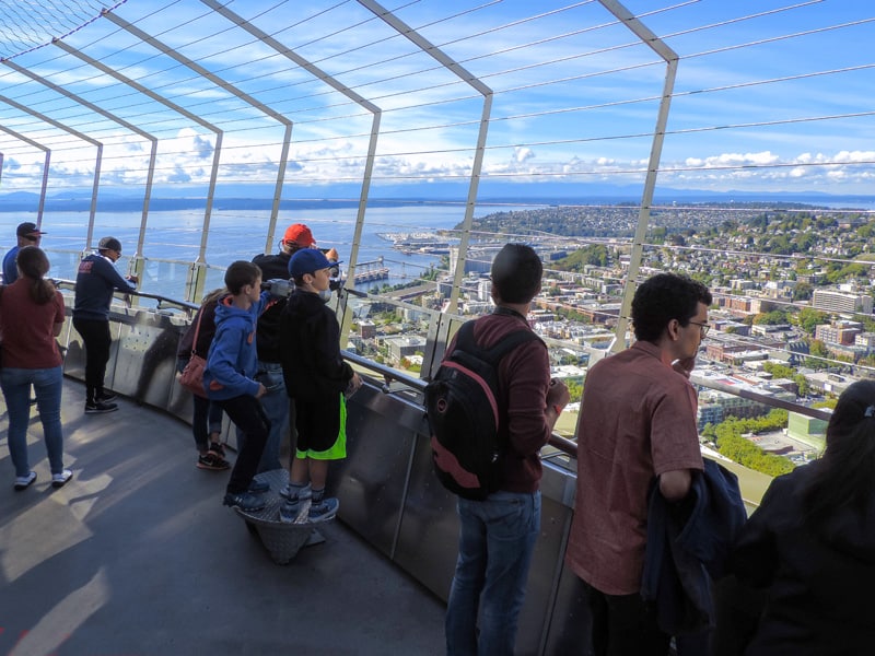 people looking out from the space needle - one of the things to do in Seattle