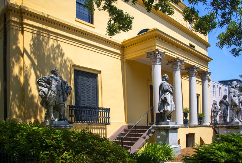 statues in front of a yellow building