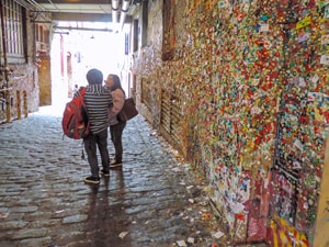2 women by a wall covered with gum