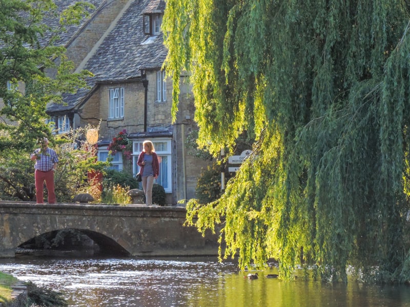people walking along a river - one of the things to do in the Cotswolds