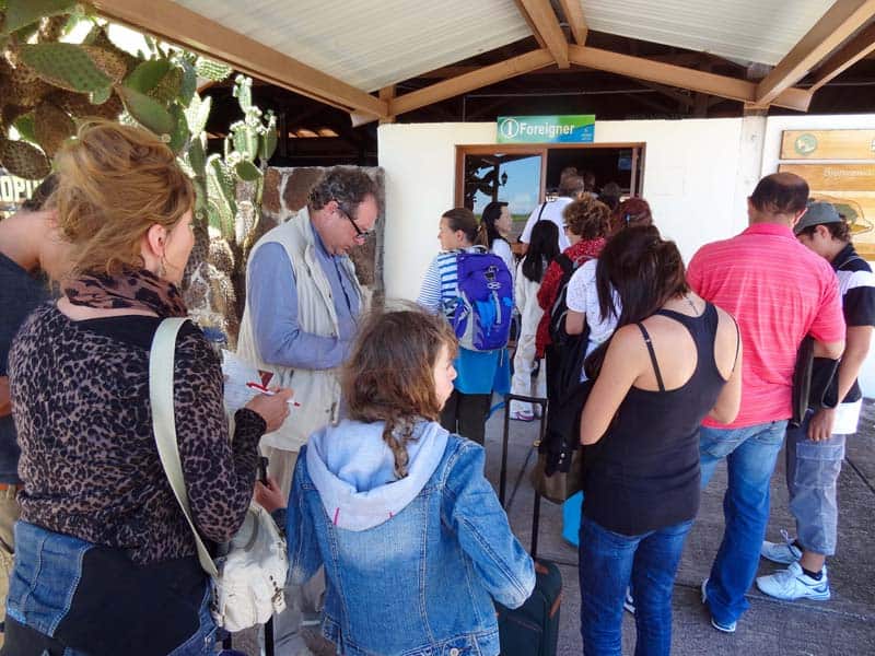 people standing outside an office that has a sign saying "foreigner"