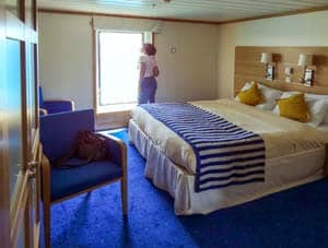 a woman looking at the wind of a ship's stateroom