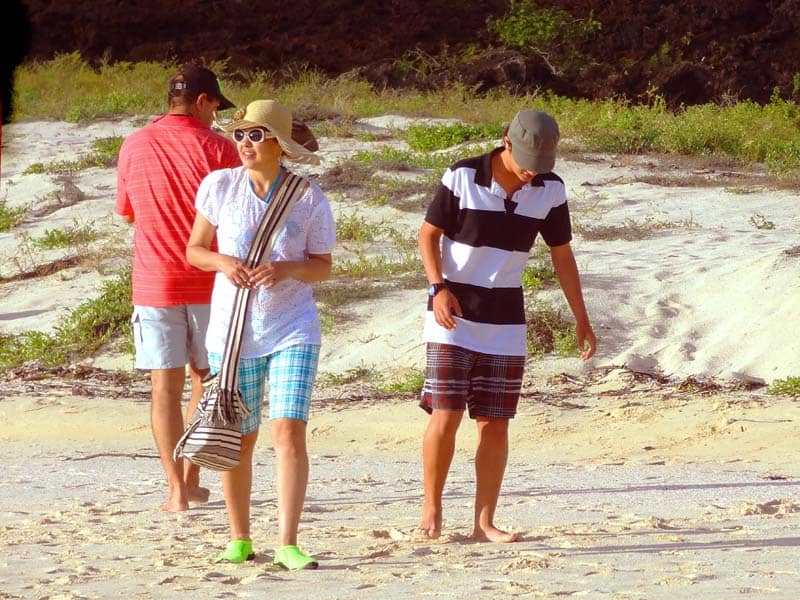 two boys and a girl walking along a beach