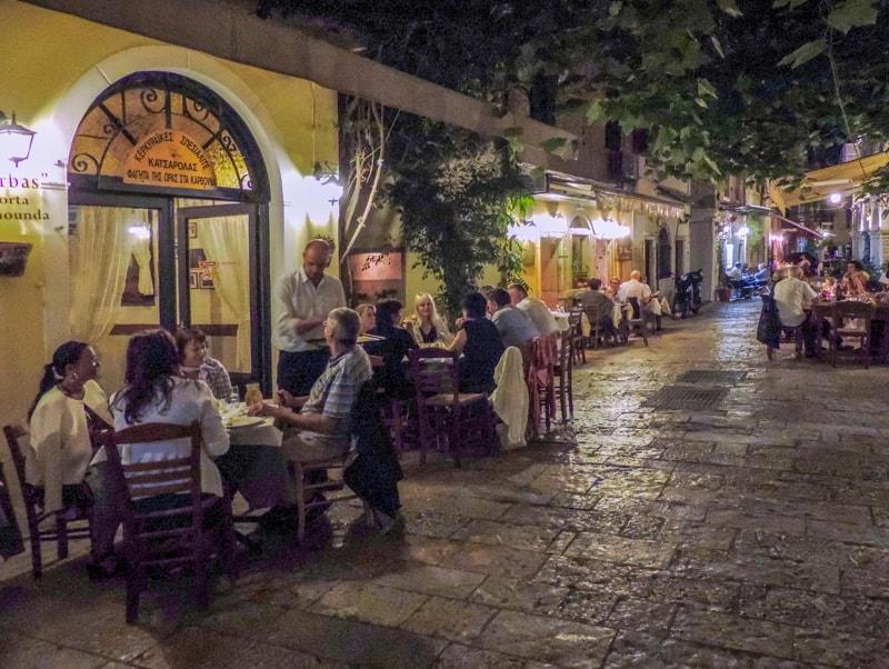 people dining in outdoor restaurants in the evening– one of the things to do in Corfu