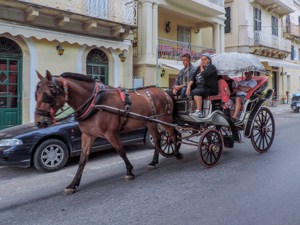 people in a horse-drawn carriage in Old Town - one of the things to do in Corfu