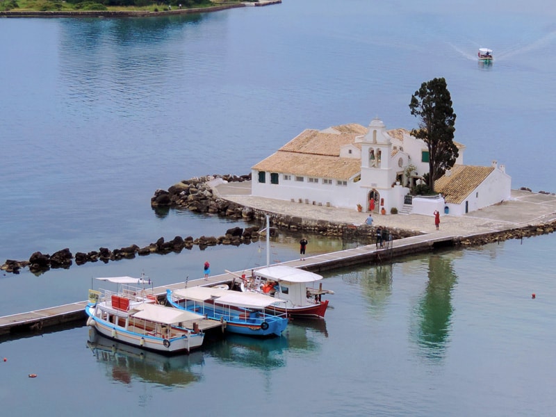 people visiting a monastery on a lake - one of the things to do in Corfu