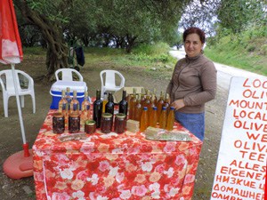a woman at her roadside stand selling honey and olive oil