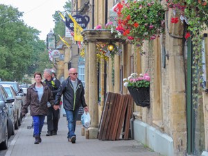 people walking by old buildings