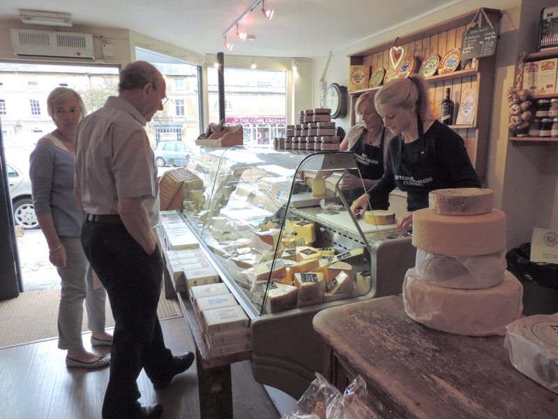 people buying cheese in a shop - one of the things to do in the Cotswolds