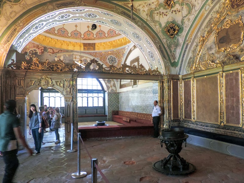people in an ornate room in a palace, one of the things to do in Istanbul