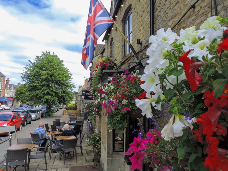 bright flowers above people relaxing at a table -  one of the things to do in the Cotswolds