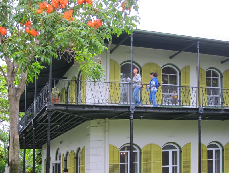 people on a veranda of a house with green shutters - what to do in Key West