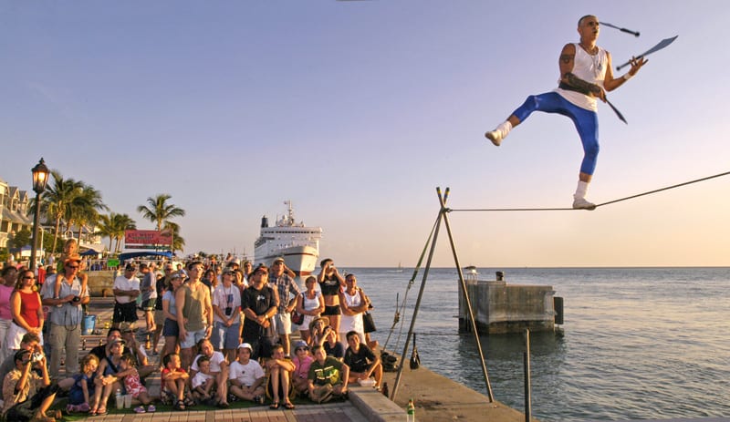 a crowd watching a man on a tightrope juggling - what to do in Key West