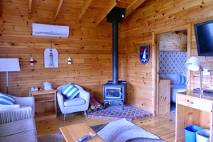 a bedroom with cedar-planked walls at Liscombe Lodge