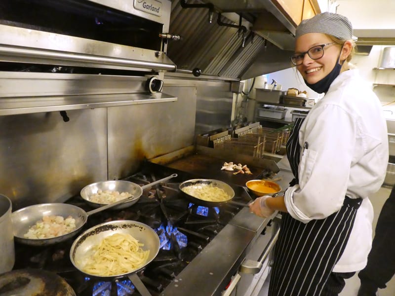 a chef at a stove preparing a meal