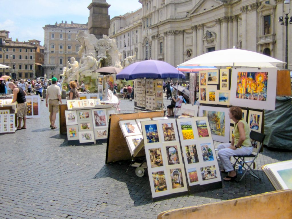artists sitting with the paintings in a large square