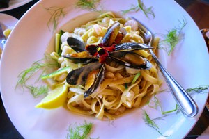 a plate with a meal of past and seafood