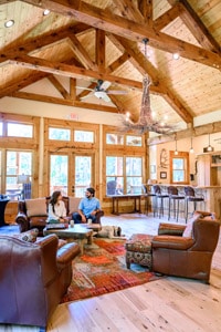 a couple sitting beneath high wooden beams in a hotel lobby