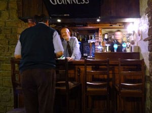 two men chatting at a bar