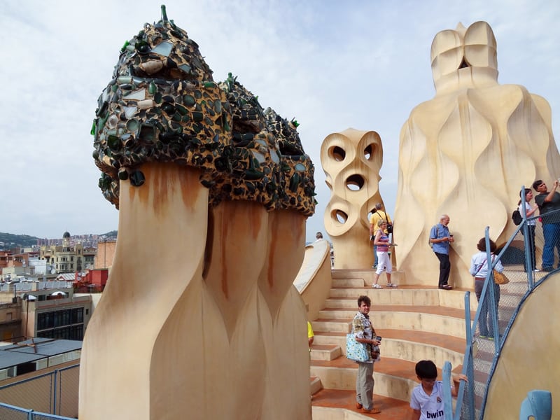 people on a roof by large chimneys - on one of the Gaudi buildings