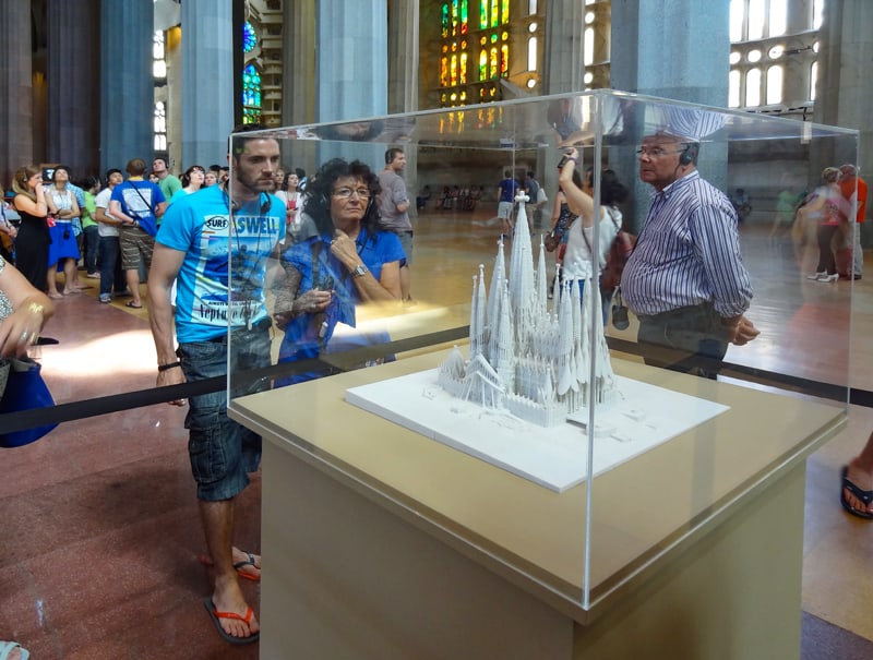 people looking at a model of a cathedral