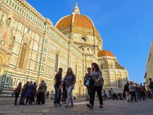 people walking by a large basilica