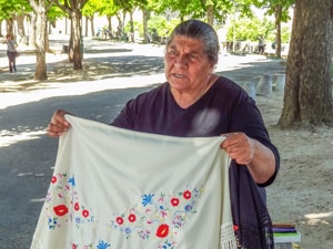 a woman selling handmade taablecloths