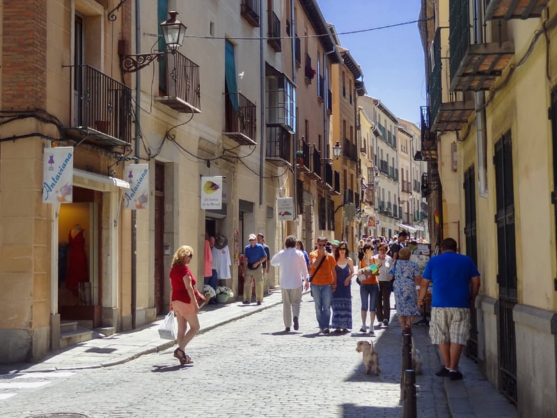 people walking down a street in an old city on a day trip to Segovia from Madrid
