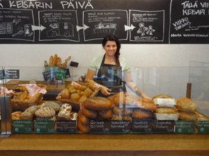 a woman selling bread in a bakery