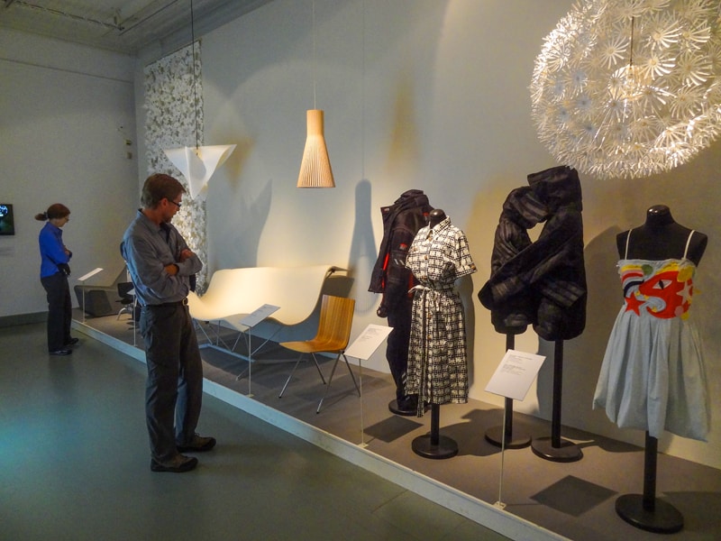 people looking at an exhibit of clothing in a museum, one of the things to do in Helsinki
