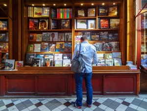 man looking at a bookstore in one of the hidden passages of Paris