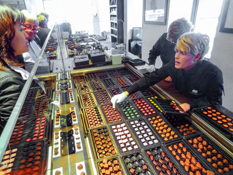 a women buying chocolates in a shop, something to do when looking for good Brussels food