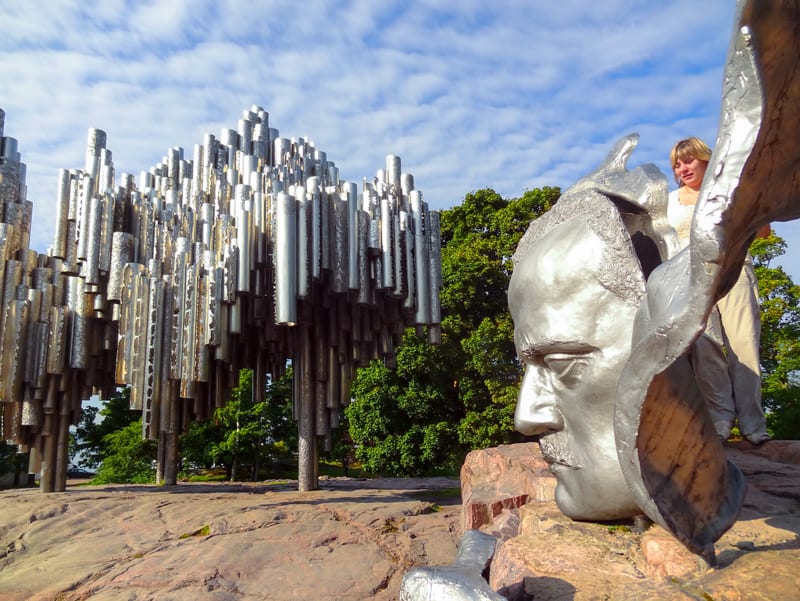 a woman by an outdoor sculpture of the composer Jean Sibelius