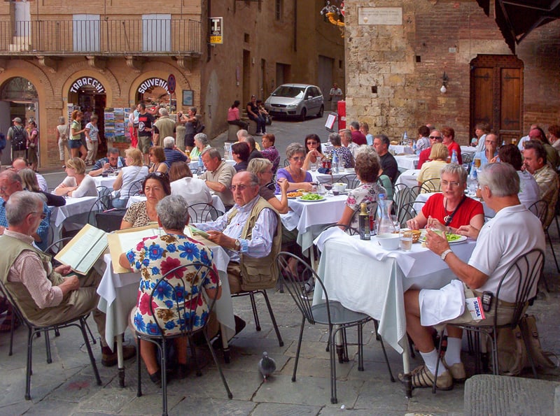 people eating at an outdoor restaurant - something to do when you rent a villa in Italy