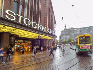 people walking across a street to a tram