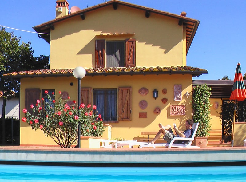 many reading a book by a pool - rent a villa in Italy