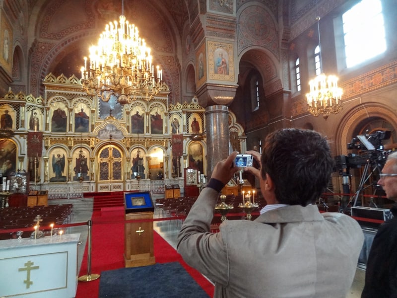 a man taking a photo inside a beautiful, old, ornate cathedral