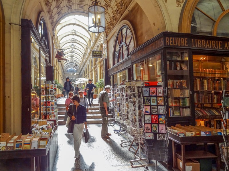 people walkin g past a bookstore in one of the hidden passages of Paris