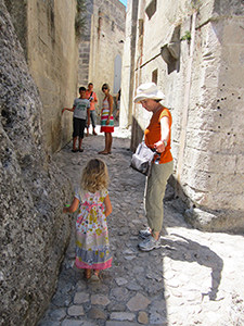 a woman helping a small child in the Sassi in Matera