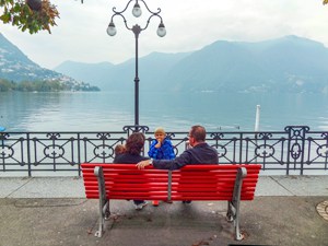 a family sitting by a lake, one of the things to do in Lugano