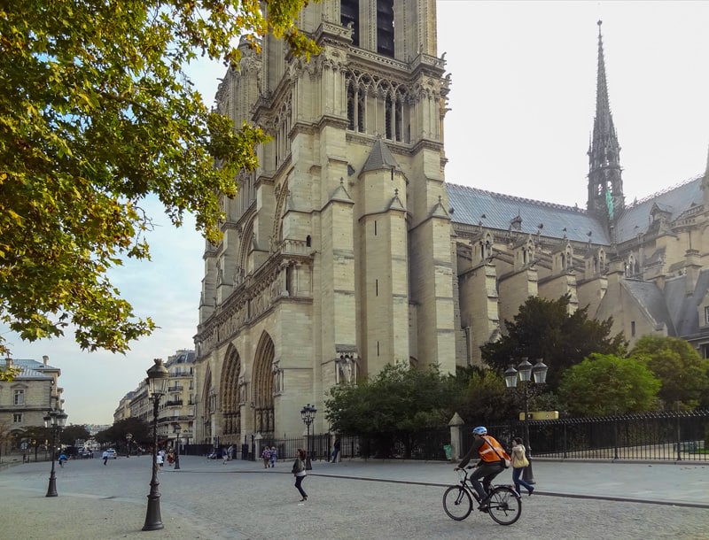 A bicyclists passing Notre Dame - one of the best places in Paris to see