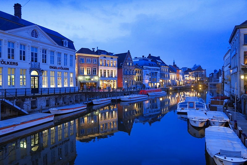 people walking along a canal in the evening, one of the things to do in Ghent