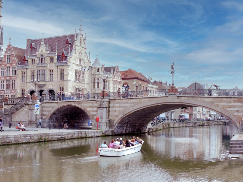 people in a tour boat approaching a bridge