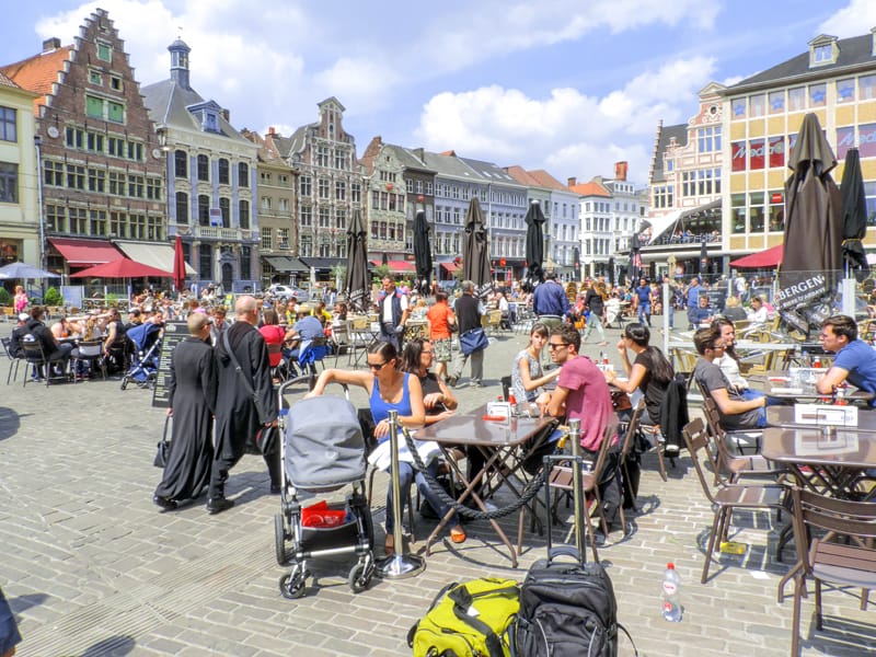 a crowd of people in cafes on an old city plaza