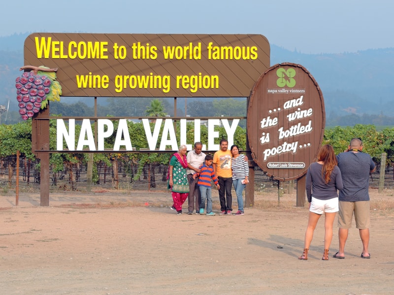 people having the ohoto taken in front of a large Napa Valley billboard - one of the things to do in Napa Valley