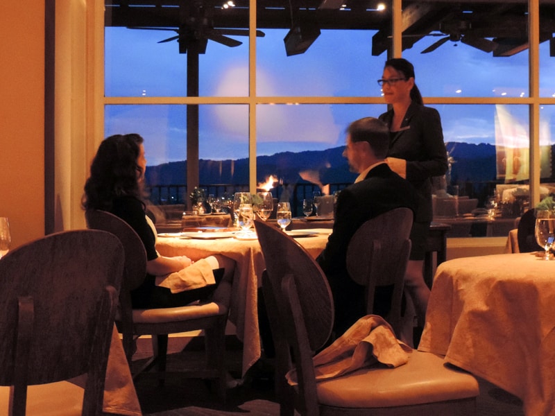 a waitress speaking with people in a four-star restaurant