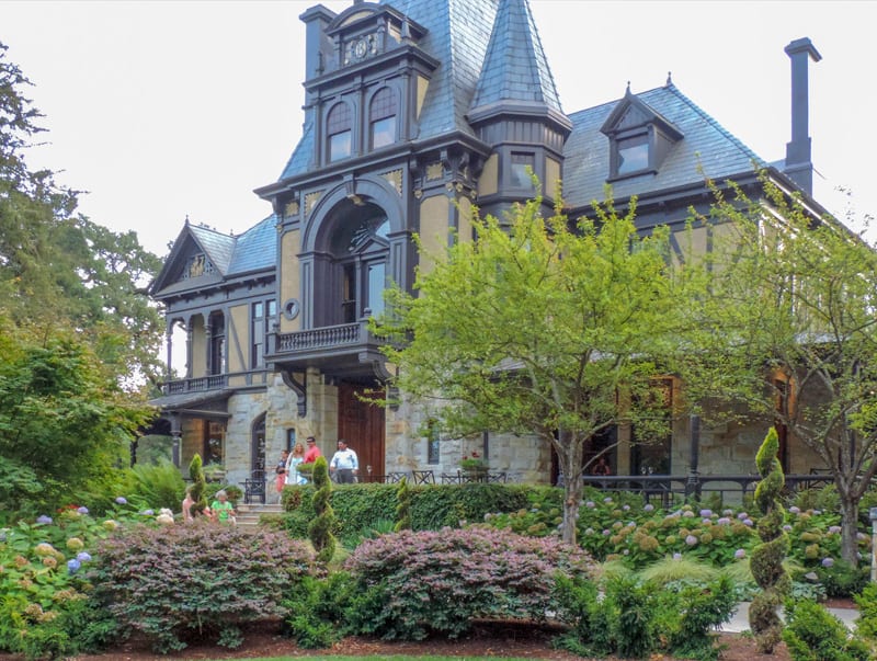 people outside a large Goth-style house 