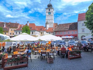 people in a cafe near a clock tower, , one of the things to do in Romania